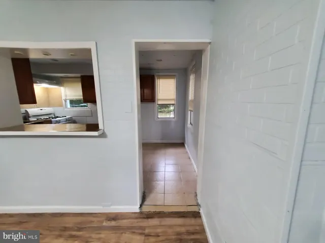 a view of a hallway with wooden floor and a living room