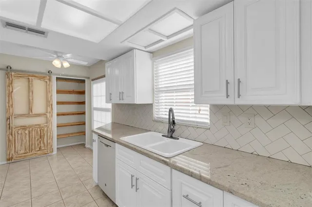 a kitchen with white cabinets and refrigerator