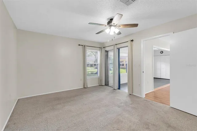 an empty room with closet and a ceiling fan