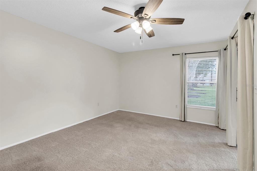 4814 Grist Mill Circle New Port Richey, FL 34655 - Photo 19 of 63 an empty room with closet and a ceiling fan