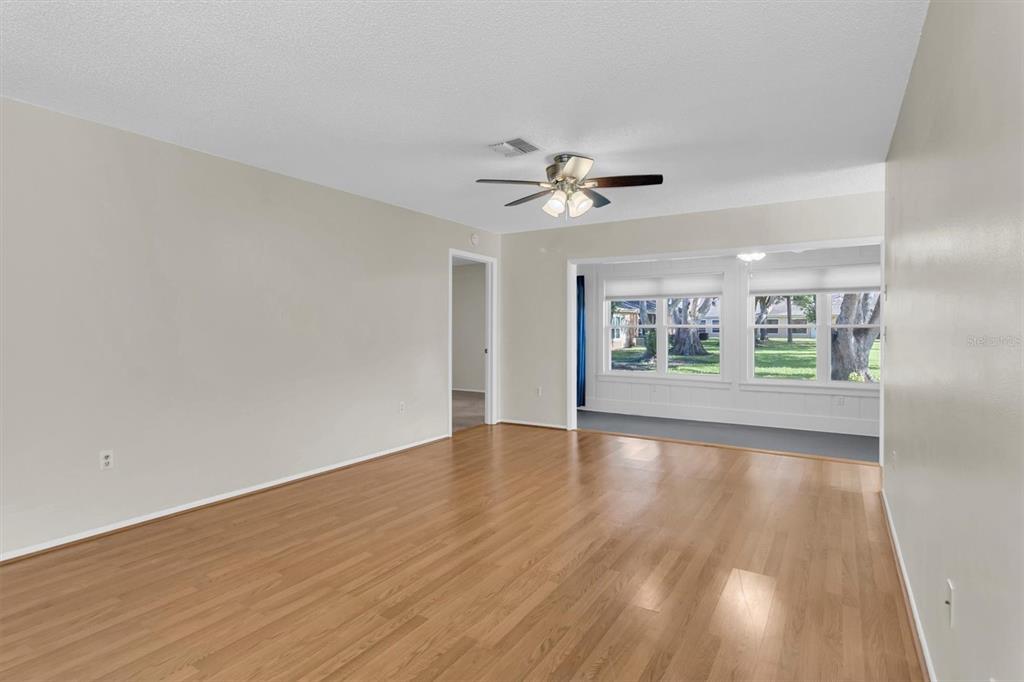 4814 Grist Mill Circle New Port Richey, FL 34655 - Photo 6 of 63 a view of an empty room with a window and wooden floor
