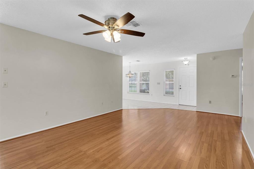 4814 Grist Mill Circle New Port Richey, FL 34655 - Photo 8 of 63 an empty room with wooden floor and windows