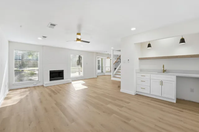 a view of a kitchen with wooden floor and a fireplace