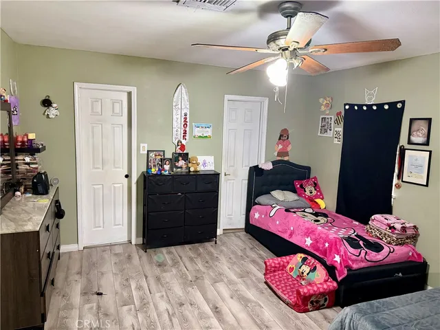a bedroom with a bed closet and dresser