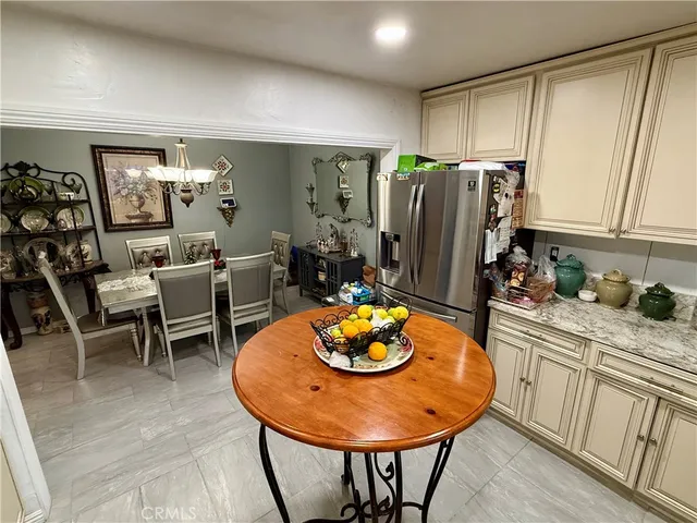 a kitchen with stainless steel appliances granite countertop a stove a refrigerator and a dining table with wooden floor