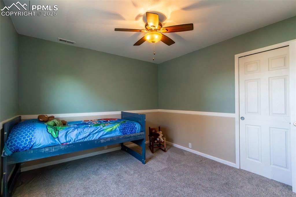 7544 Jaoul Point Peyton, CO 80831 - Photo 19 of 37 a room with a bed and a chandelier