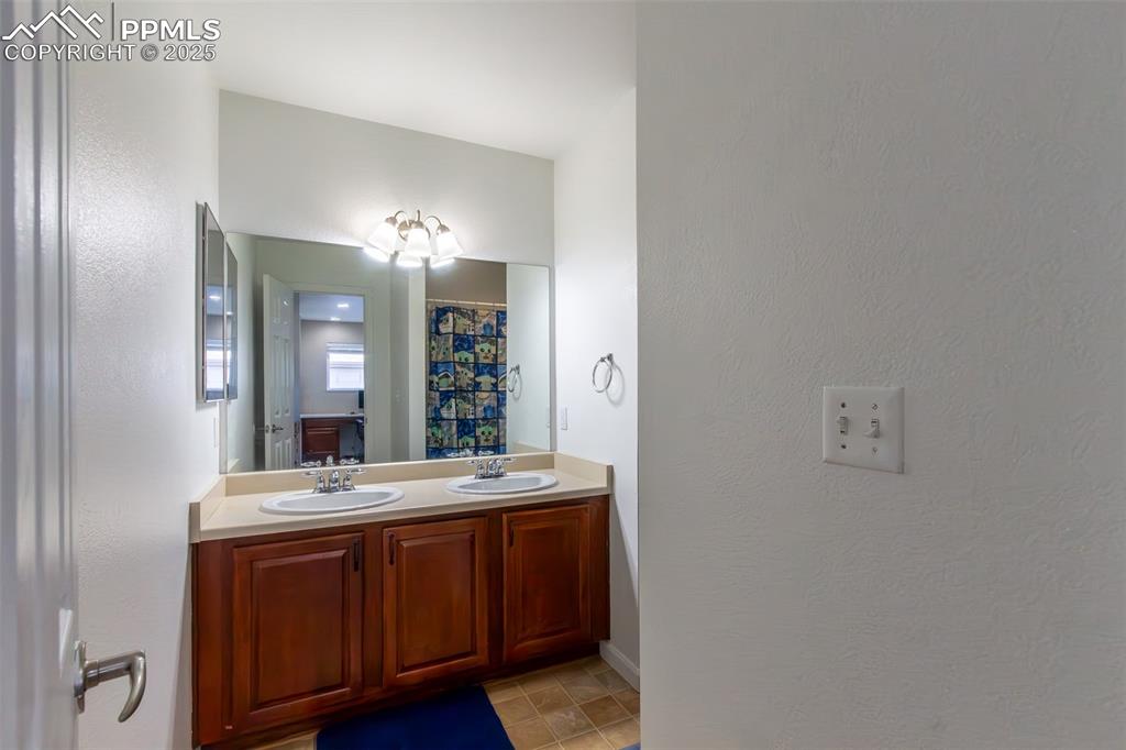 7544 Jaoul Point Peyton, CO 80831 - Photo 24 of 37 a bathroom with a double vanity sink and a mirror