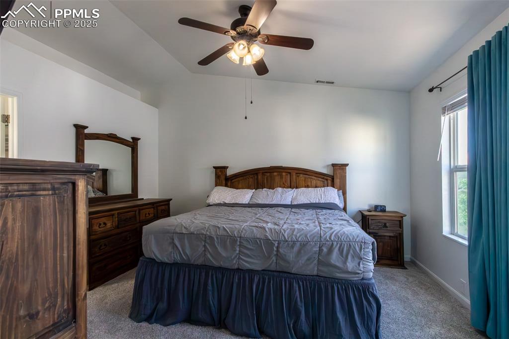 7544 Jaoul Point Peyton, CO 80831 - Photo 27 of 37 a bedroom with a bed and a chandelier