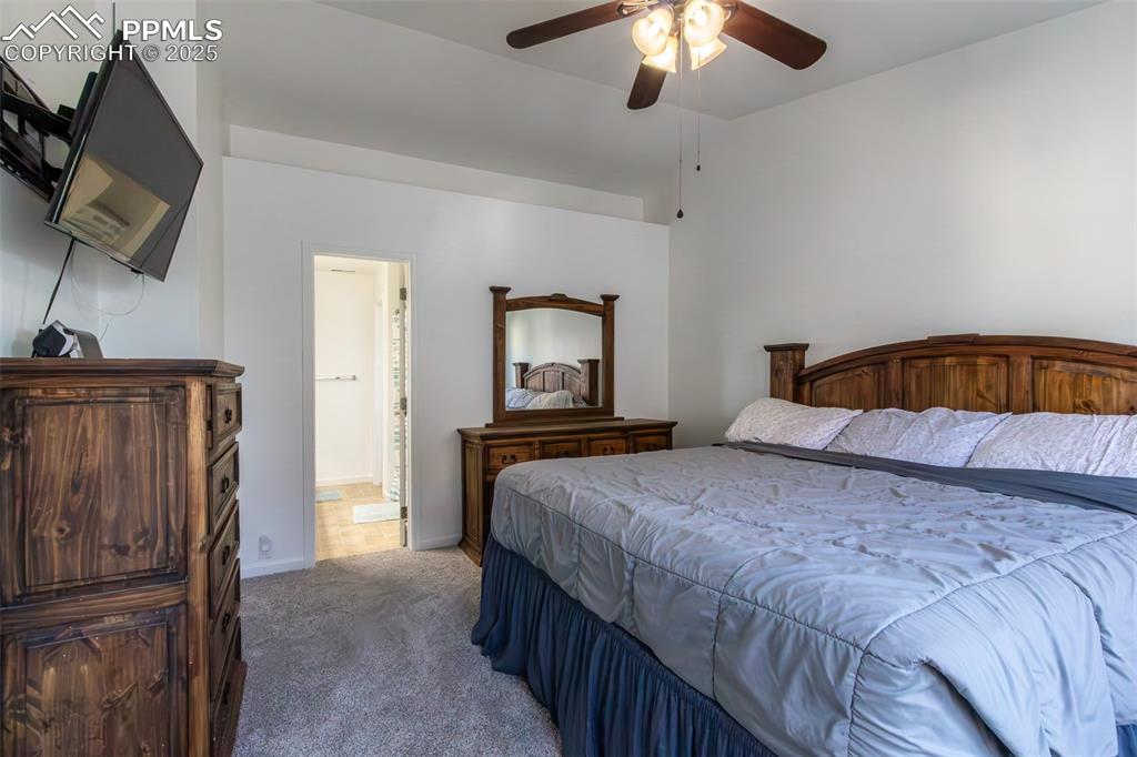 7544 Jaoul Point Peyton, CO 80831 - Photo 28 of 37 a bedroom with a bed and a chandelier