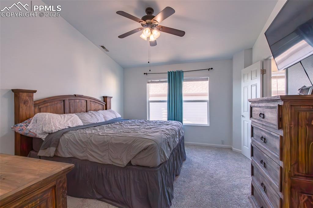 7544 Jaoul Point Peyton, CO 80831 - Photo 29 of 37 a bedroom with a bed and a chandelier
