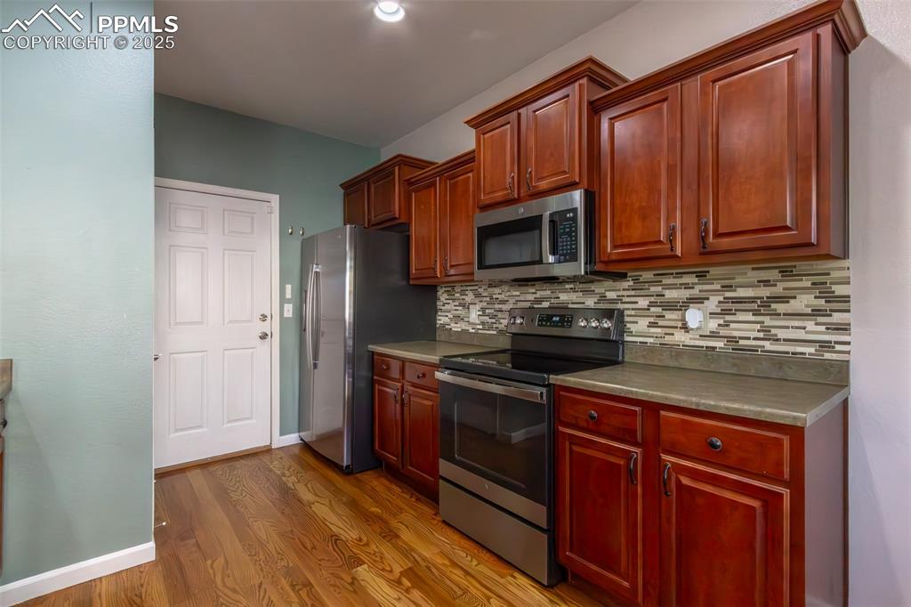 7544 Jaoul Point Peyton, CO 80831 - Photo 10 of 37 a kitchen with granite countertop wooden cabinets and a stove top oven