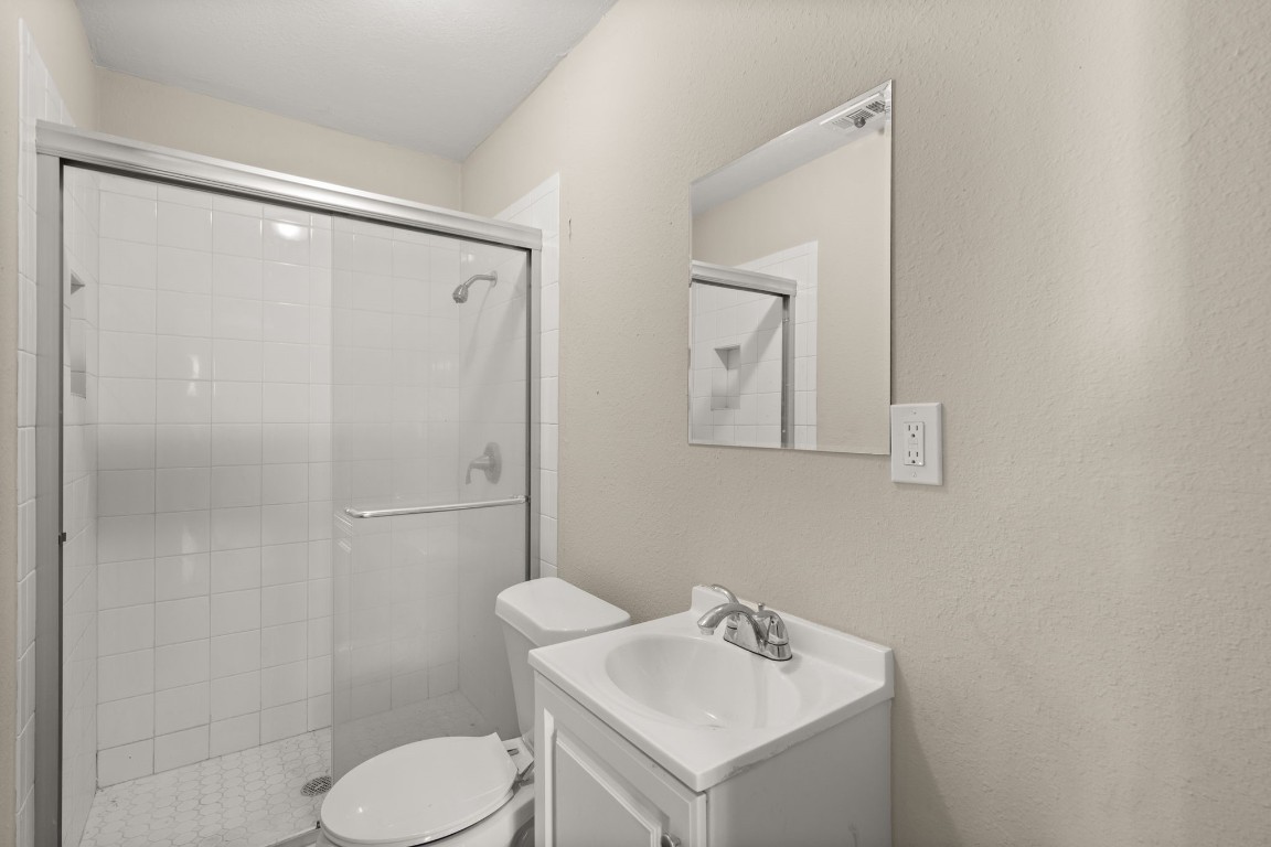 3031 Friar Point Road Houston, TX 77051 - Photo 8 of 15 Secondary bathroom features light countertops and cabinets, custom paint, walk-in shower with tile surround, mirror, tile floors, sleek fixtures and modern finishes, plenty of space to accommodate any visiting family or guests.