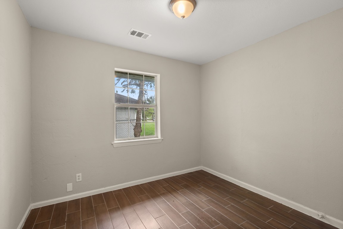 3031 Friar Point Road Houston, TX 77051 - Photo 10 of 15 Third bedroom features wood like tile floor, custom paint, and a large window to let in lots of natural lighting.