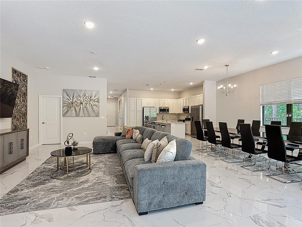 1326 Butterfly Orchid Road Davenport, FL 33837 - Photo 16 of 54 a living room with furniture kitchen view and a flat screen tv