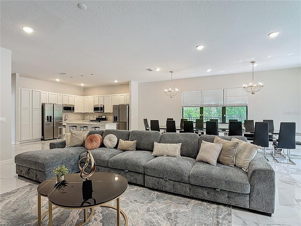 1326 Butterfly Orchid Road Davenport, FL 33837 - Photo 18 of 54 a living room with furniture kitchen view and a chandelier
