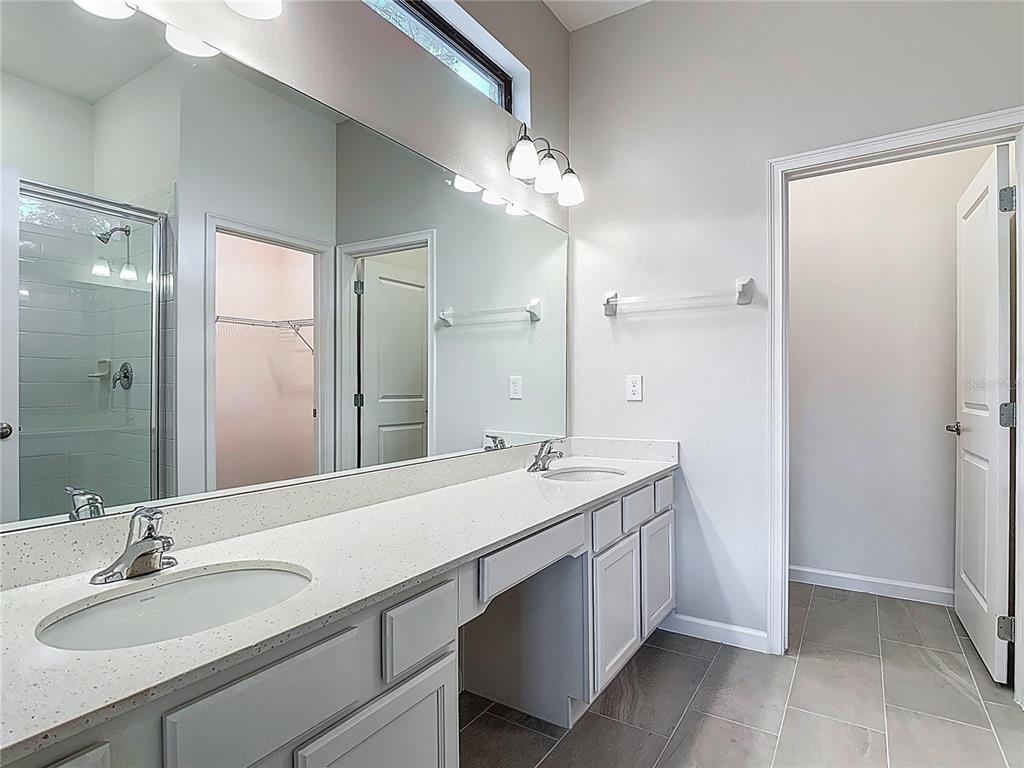 1326 Butterfly Orchid Road Davenport, FL 33837 - Photo 21 of 54 a bathroom with a sink a vanity and a mirror