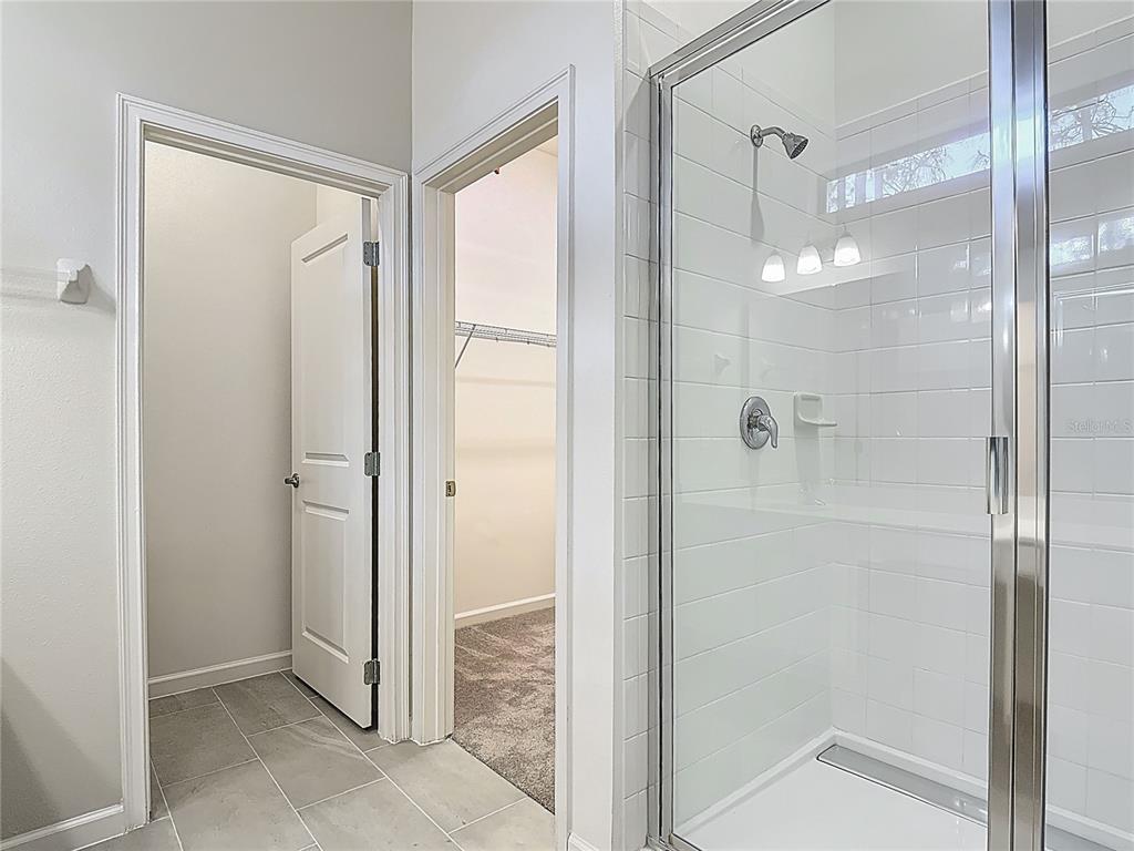 1326 Butterfly Orchid Road Davenport, FL 33837 - Photo 22 of 54 a bathroom with a shower and a glass door