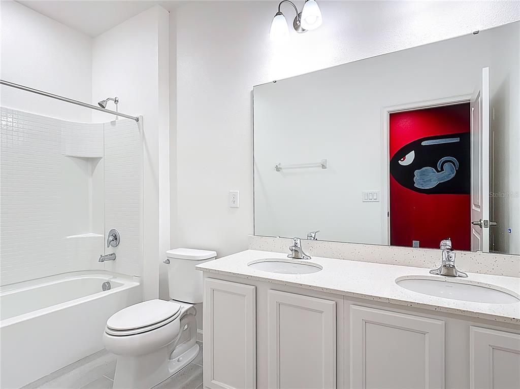 1326 Butterfly Orchid Road Davenport, FL 33837 - Photo 34 of 54 a bathroom with a toilet a sink and a bathtub