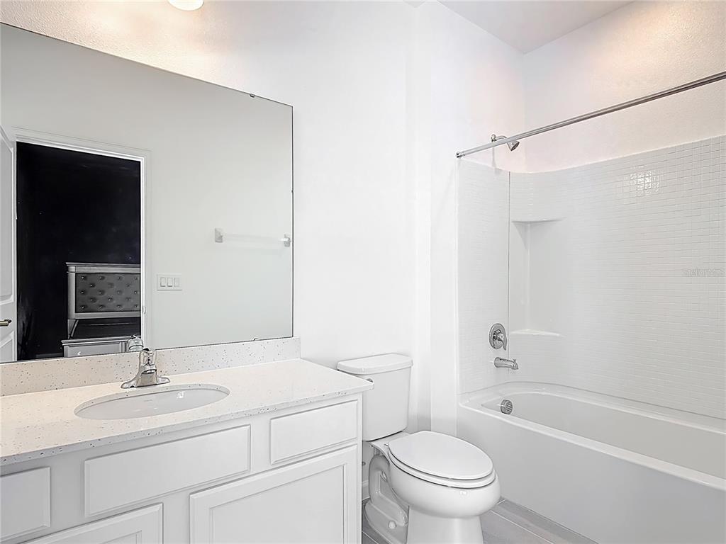 1326 Butterfly Orchid Road Davenport, FL 33837 - Photo 38 of 54 a bathroom with a granite countertop sink toilet and shower