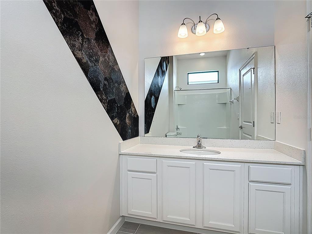 1326 Butterfly Orchid Road Davenport, FL 33837 - Photo 40 of 54 a bathroom with a sink and a mirror