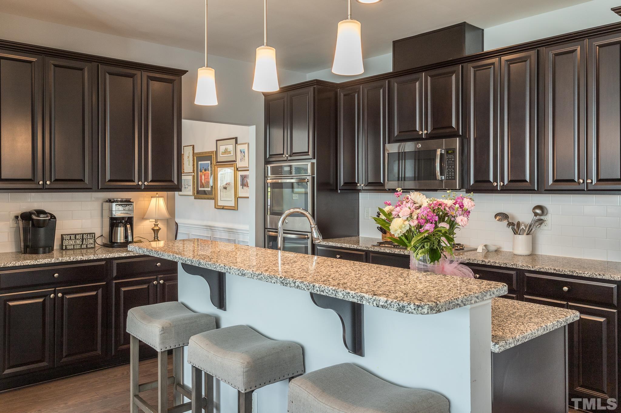 114 Willow View Lane Apex, NC 27539 - Photo 13 of 40 a kitchen with granite countertop a sink cabinets and stainless steel appliances