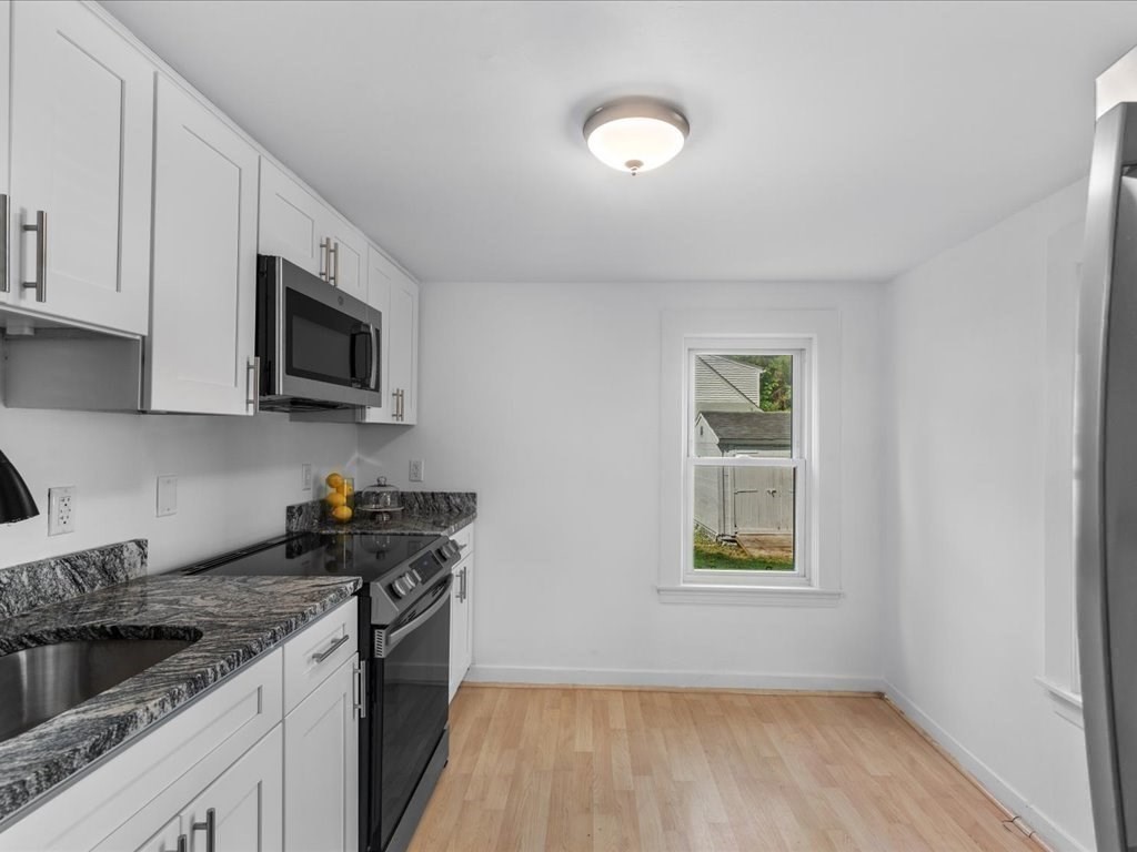 21 Ellis Street Framingham, MA 01701 - Photo 15 of 40 a kitchen with a stove a sink and a microwave