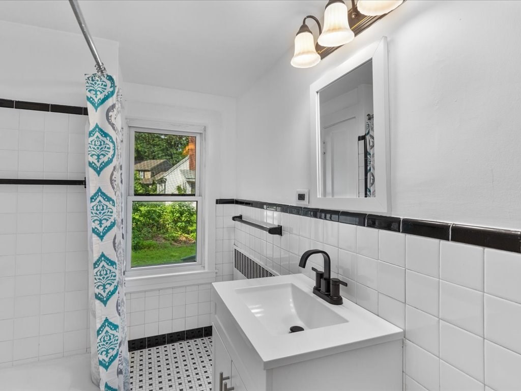 21 Ellis Street Framingham, MA 01701 - Photo 34 of 40 a bathroom with a sink a mirror and window
