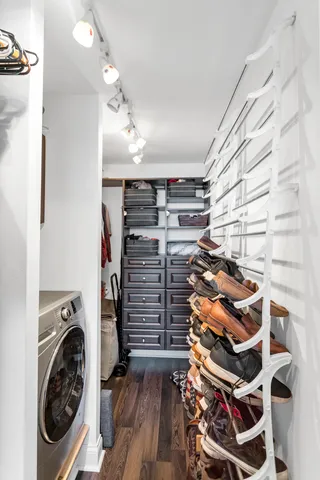 a view of walk in closet with clothes and shoes