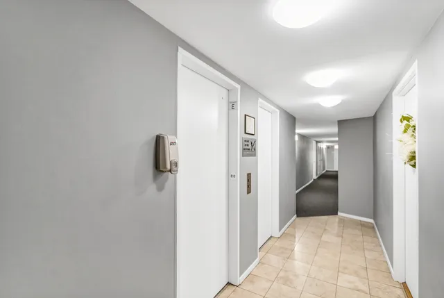 a view of a hallway with closet and wooden floor