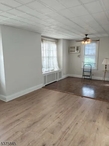 an empty room with windows and wooden floor