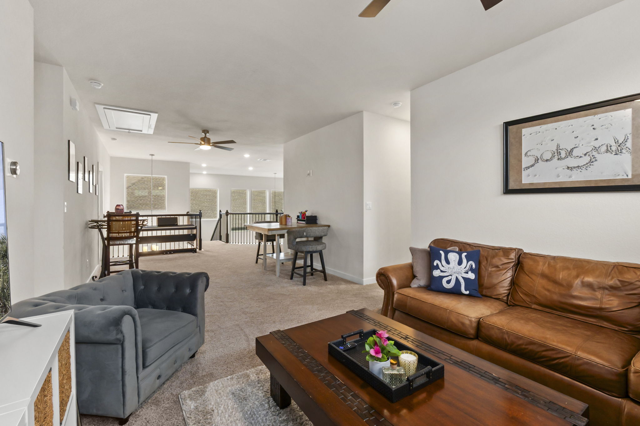 460 Constitution Way Kyle, TX 78640 - Photo 22 of 40 Carpeted upper-level living area with recessed lighting, a ceiling fan, white baluster railings, and multiple windows