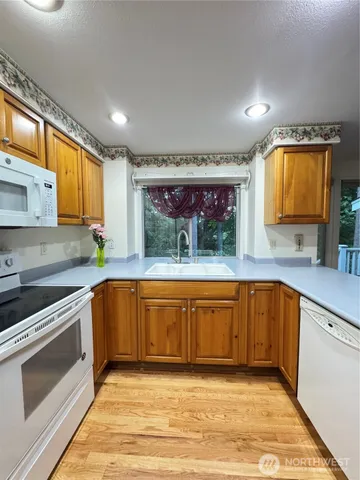 a large kitchen with stainless steel appliances granite countertop a sink and cabinets