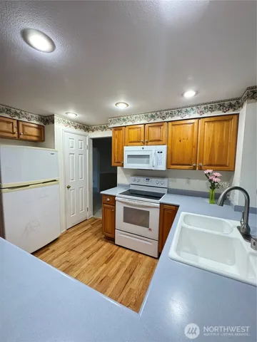 a kitchen with stainless steel appliances granite countertop a sink a stove and a refrigerator