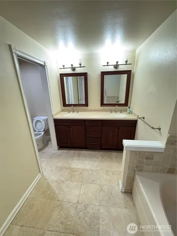 a bathroom with a tub sink and mirror