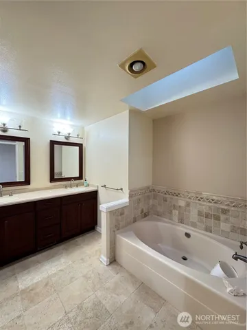 a bathroom with a granite countertop shower a sink and a mirror