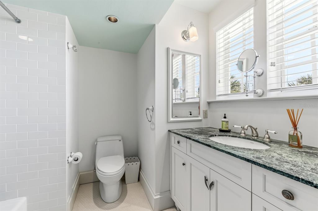 312 Baily Street Boca Grande, FL 33921 - Photo 14 of 41 a bathroom with a granite countertop toilet sink and mirror