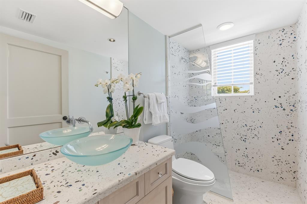 312 Baily Street Boca Grande, FL 33921 - Photo 16 of 41 a bathroom with a granite countertop sink a toilet and a mirror