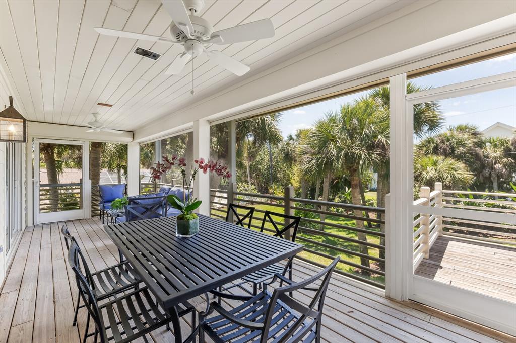 312 Baily Street Boca Grande, FL 33921 - Photo 24 of 41 a view of a patio with table and chairs floor to ceiling window with wooden floor
