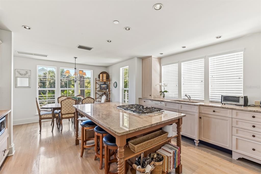 312 Baily Street Boca Grande, FL 33921 - Photo 10 of 41 a dining hall with stainless steel appliances granite countertop a stove a table and chairs with wooden floor