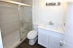 a bathroom with a sink a toilet and shower