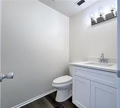 a bathroom with a toilet a sink and mirror