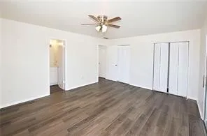 an empty room with wooden floor and ceiling fan