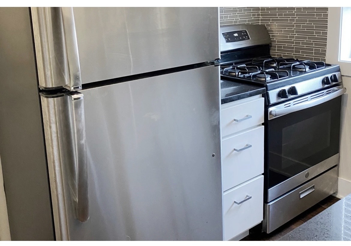 4218 North Clark Street, Unit 2 Chicago, IL 60613 - Photo 5 of 12 a kitchen with granite countertop a refrigerator and a stove