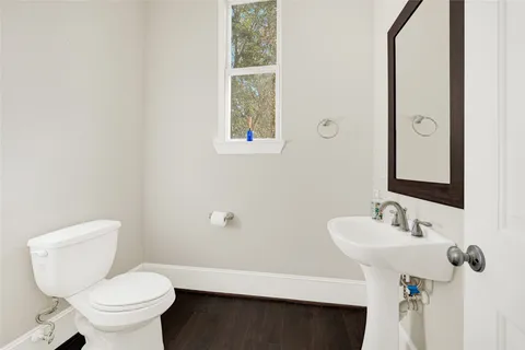 a bathroom with a toilet sink and mirror
