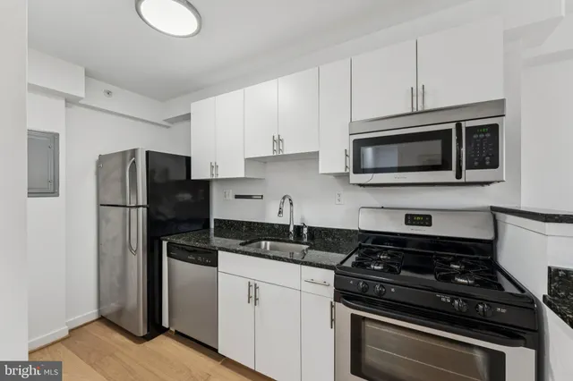 a kitchen with a stove a sink and cabinets