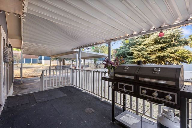 271 Mindella Way Layton, UT 84041 - Photo 24 of 27 Covered outdoor patio with a metal awning, featuring metal railings and a textured dark surface