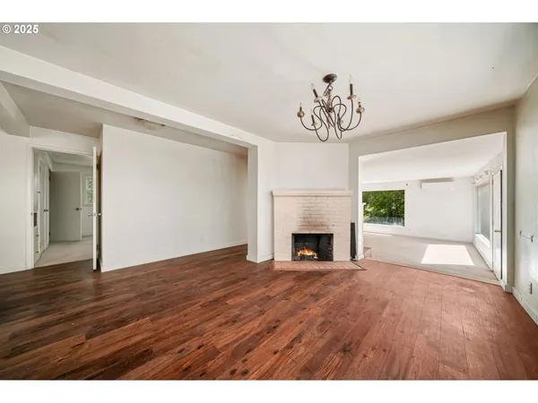 a view of empty room with fireplace and wooden floor