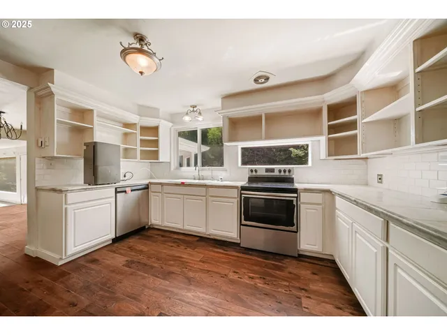 a kitchen with stainless steel appliances kitchen island granite countertop a stove and a sink