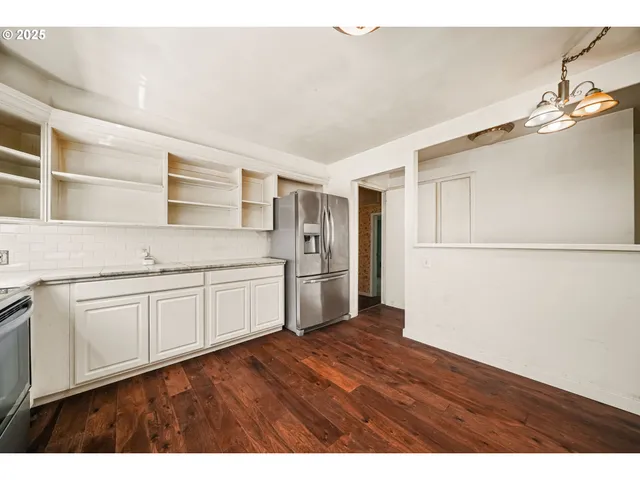 a kitchen with stainless steel appliances granite countertop a refrigerator sink and white cabinets