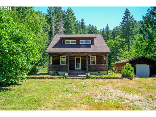 a front view of house with yard and trees in the background